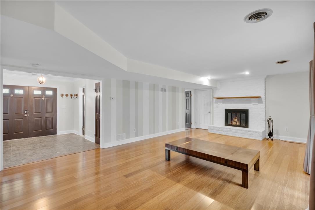 3396 Darien Road Bethlehem, PA 18020 - Photo 10 of 44 Hardwood floors stretch across this living space, warmed by a white brick fireplace.