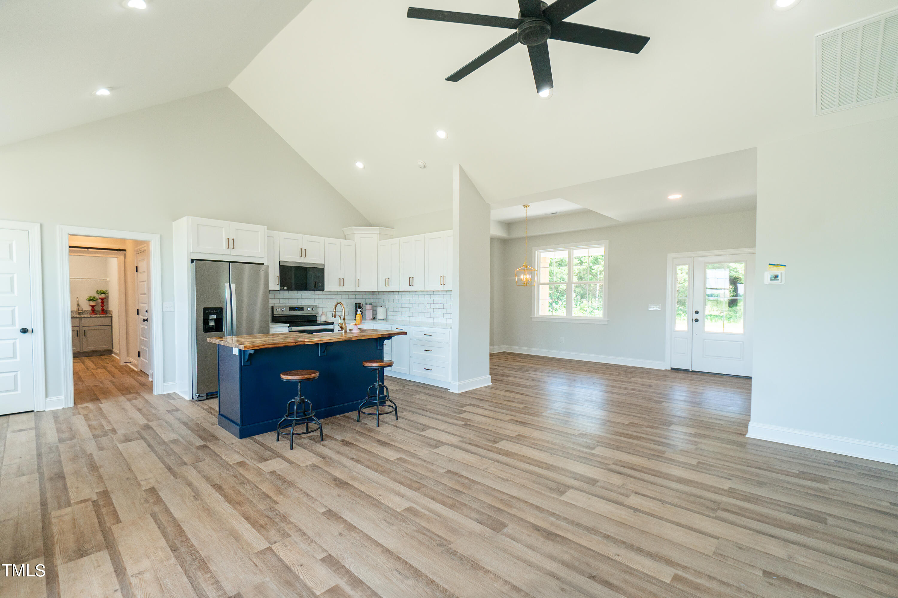 6591 Green Path Road Dunn, NC 28334 - Photo 12 of 25 a large kitchen with stainless steel appliances kitchen island granite countertop a refrigerator a stove top oven a sink dishwasher and white cabinets with wooden floor