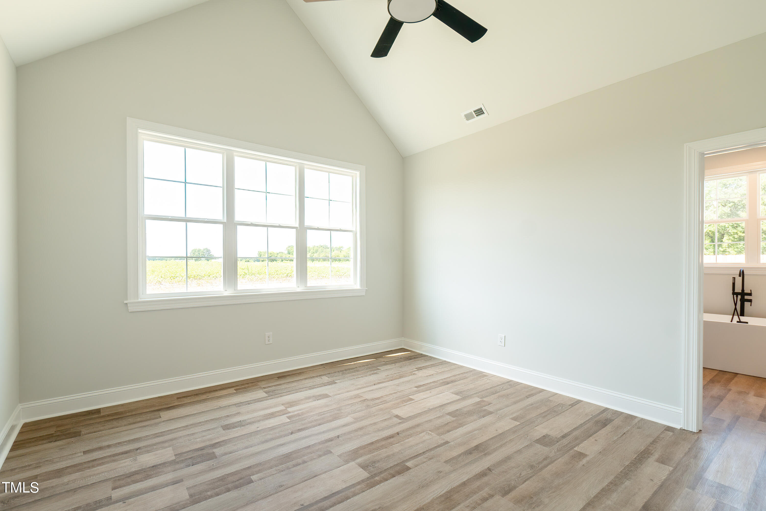 6591 Green Path Road Dunn, NC 28334 - Photo 13 of 25 an empty room with wooden floor and windows