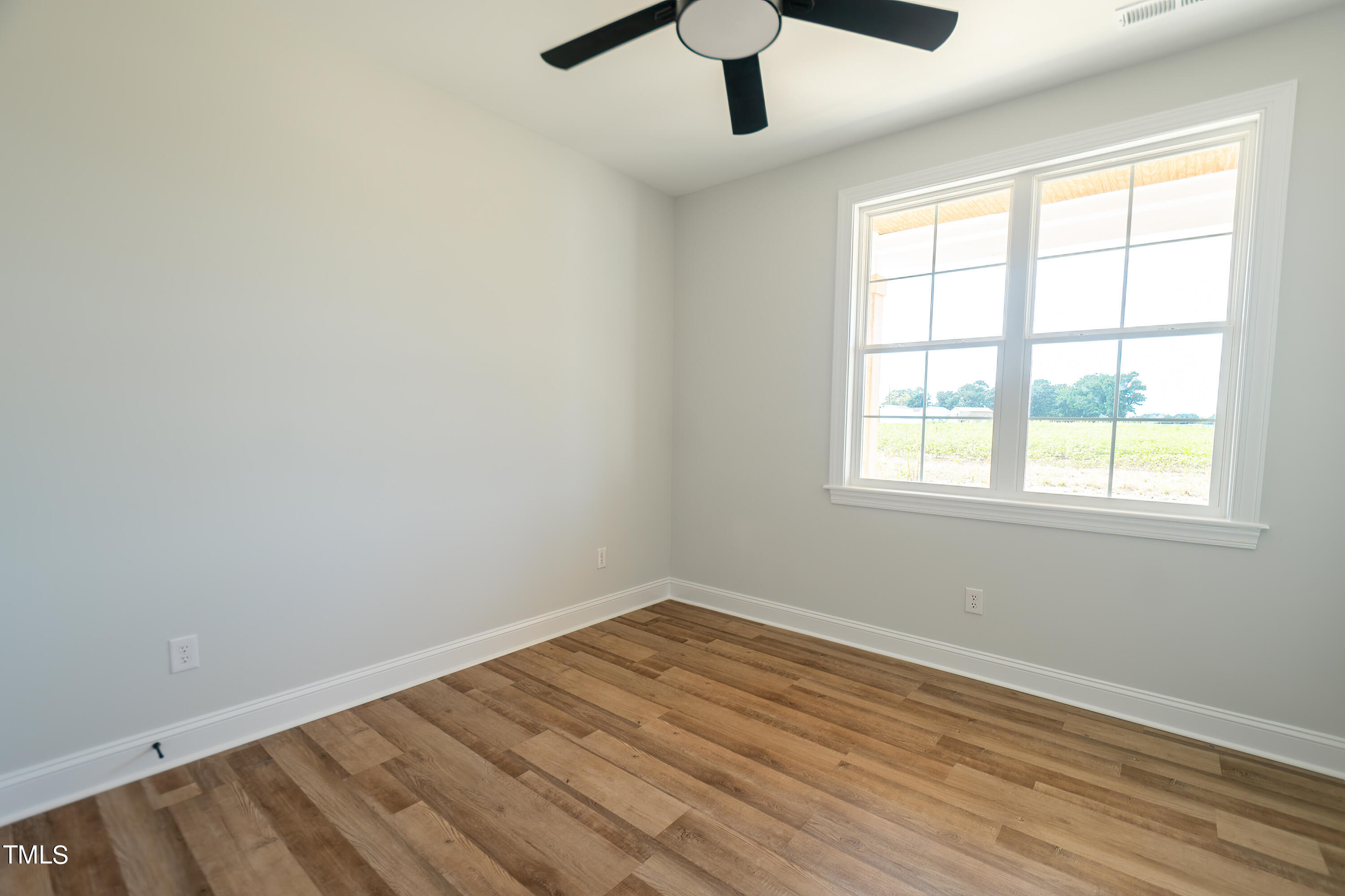 6591 Green Path Road Dunn, NC 28334 - Photo 21 of 25 an empty room with a window and a ceiling fan