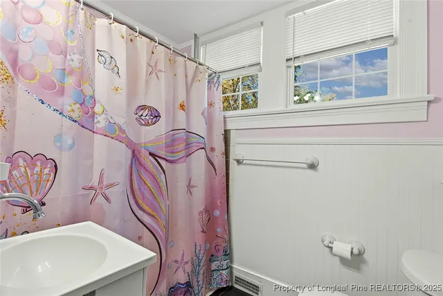 a bedroom with a bed chandelier and a window