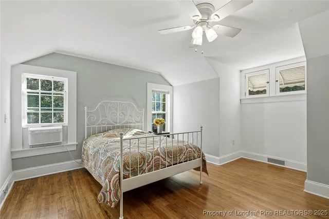 a bed sitting in a spacious bedroom next to a window