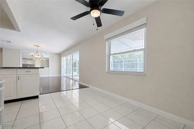 a kitchen with granite countertop white cabinets and window