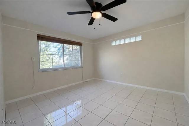 an empty room with windows and fan