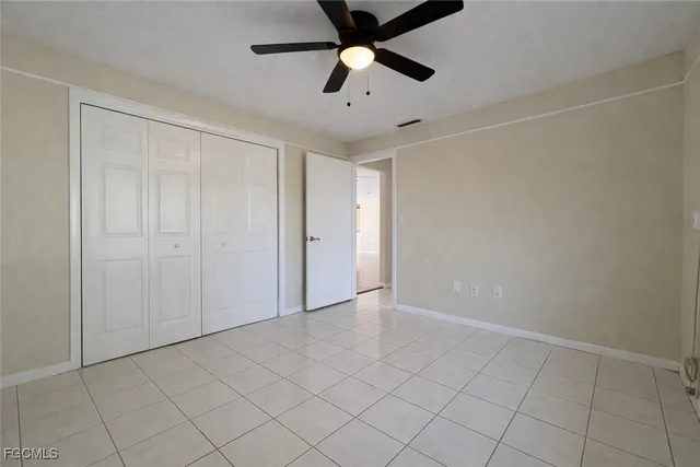 an empty room with chandelier fan
