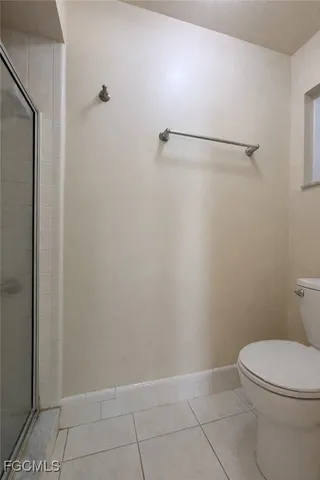 a white toilet sitting next to a shower