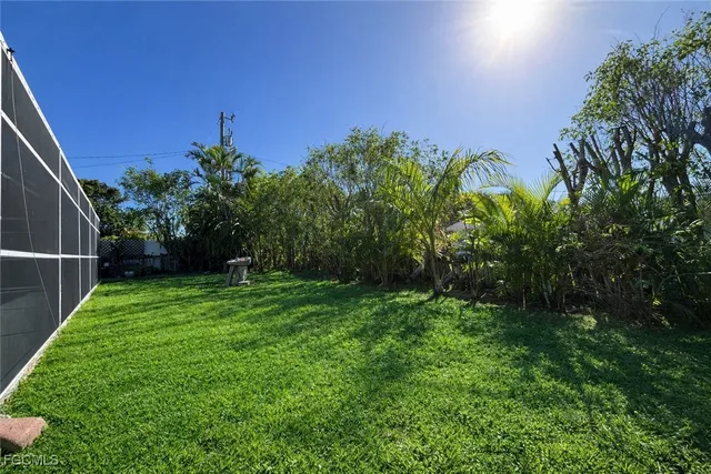 a view of a yard with an tree and a fence