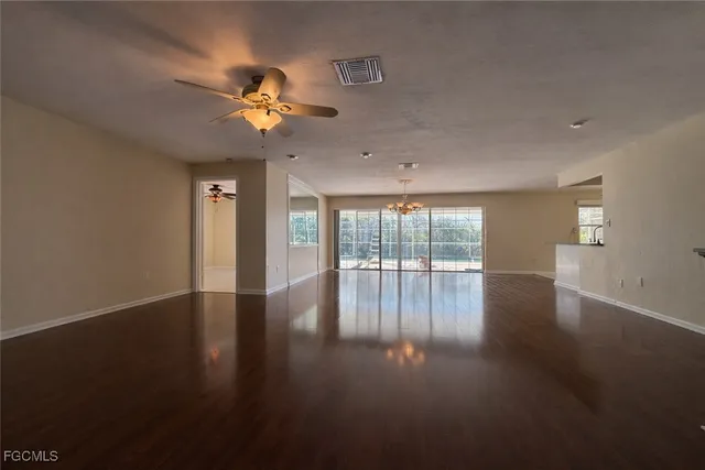 a view of wooden floor and a chandelier fan in a room