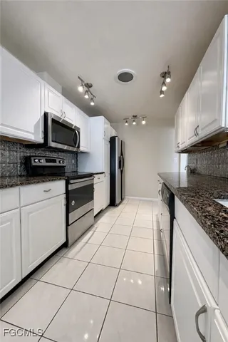 a kitchen with stainless steel appliances kitchen island granite countertop a sink and a stove