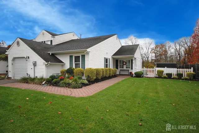 a front view of a house with a garden and yard