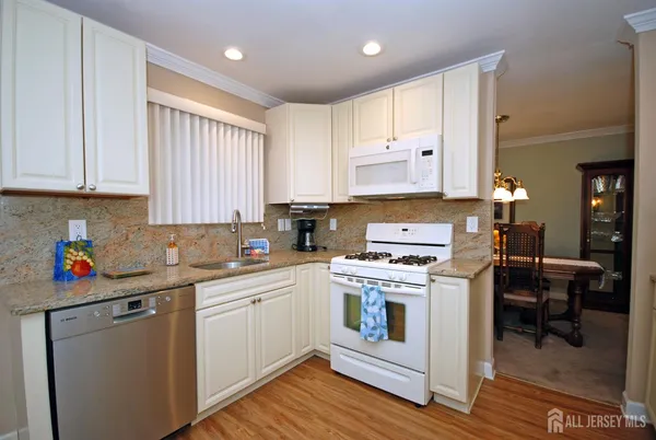 a kitchen with a stove white cabinets and wooden floor