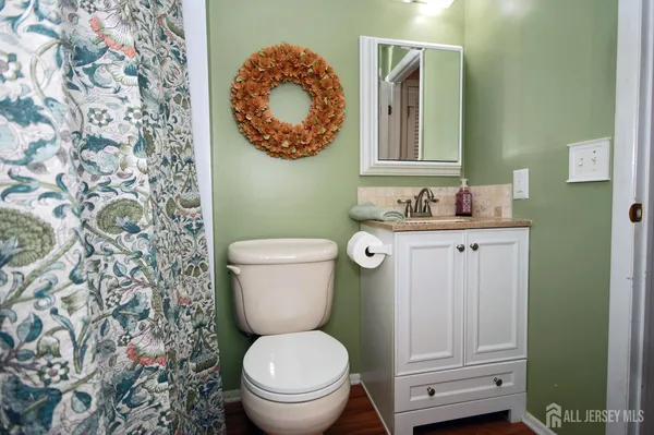 a bathroom with a toilet a sink and mirror