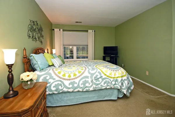 a bed sitting in a bedroom next to a window