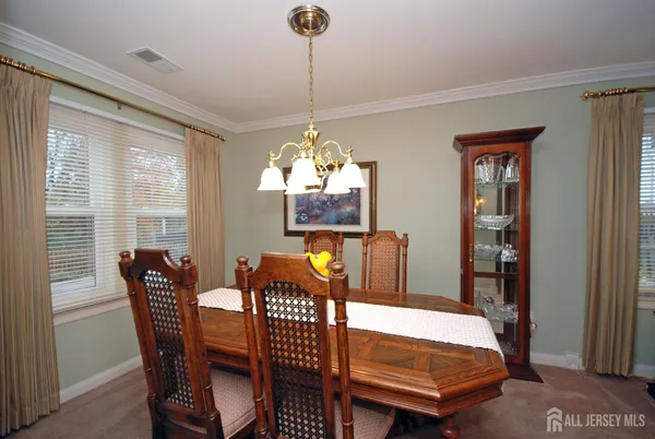 a dining room with furniture a chandelier and window