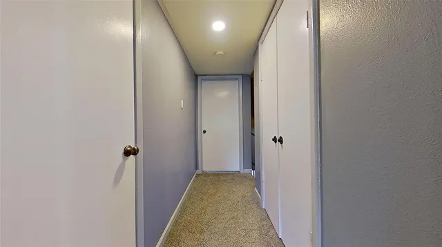a view of a hallway with a livingroom and a bathroom with a sink