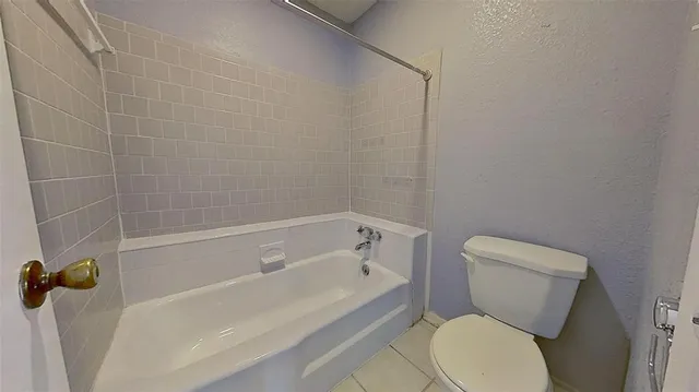 a white toilet and tub sitting next to a bathroom sink