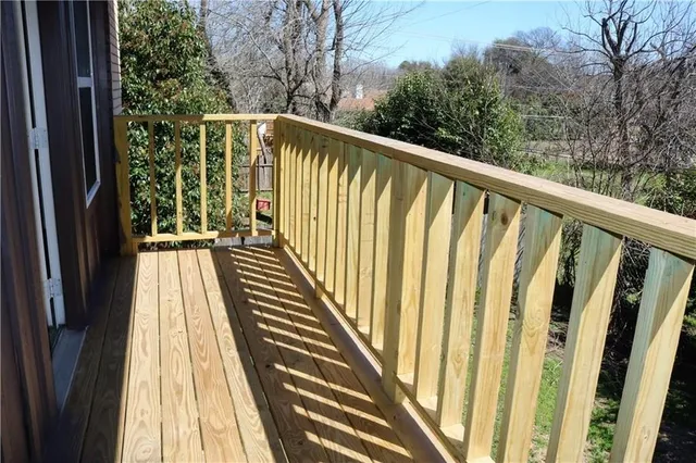 a view of balcony with wooden floor and fence