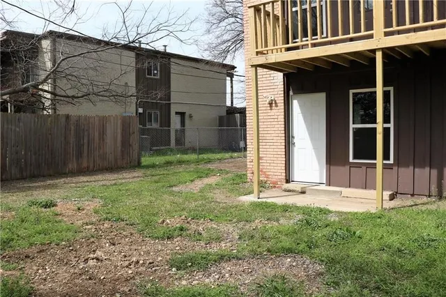 a view of a house with backyard and wooden fence