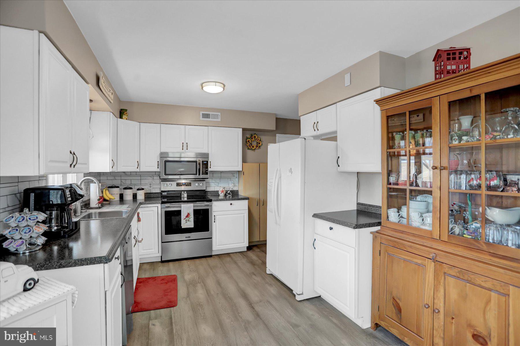 26 West Shortcut Road Newport, PA 17074 - Photo 9 of 37 a kitchen with stainless steel appliances a refrigerator a stove a sink dishwasher and white cabinets with wooden floor