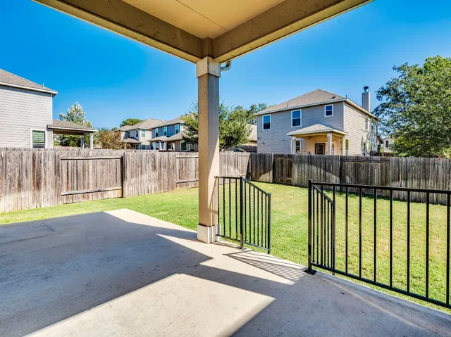 a view of a backyard with wooden fence