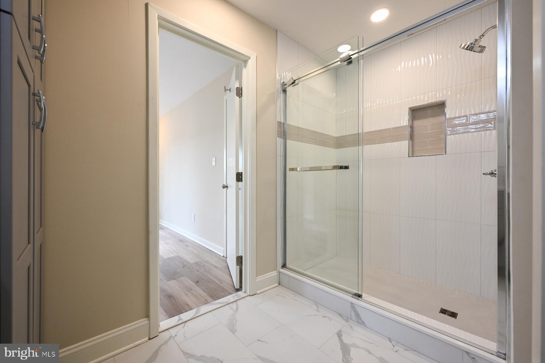 1717 Porters Hill Road Annapolis, MD 21401 - Photo 15 of 27 a bathroom with a glass shower door and a glass door