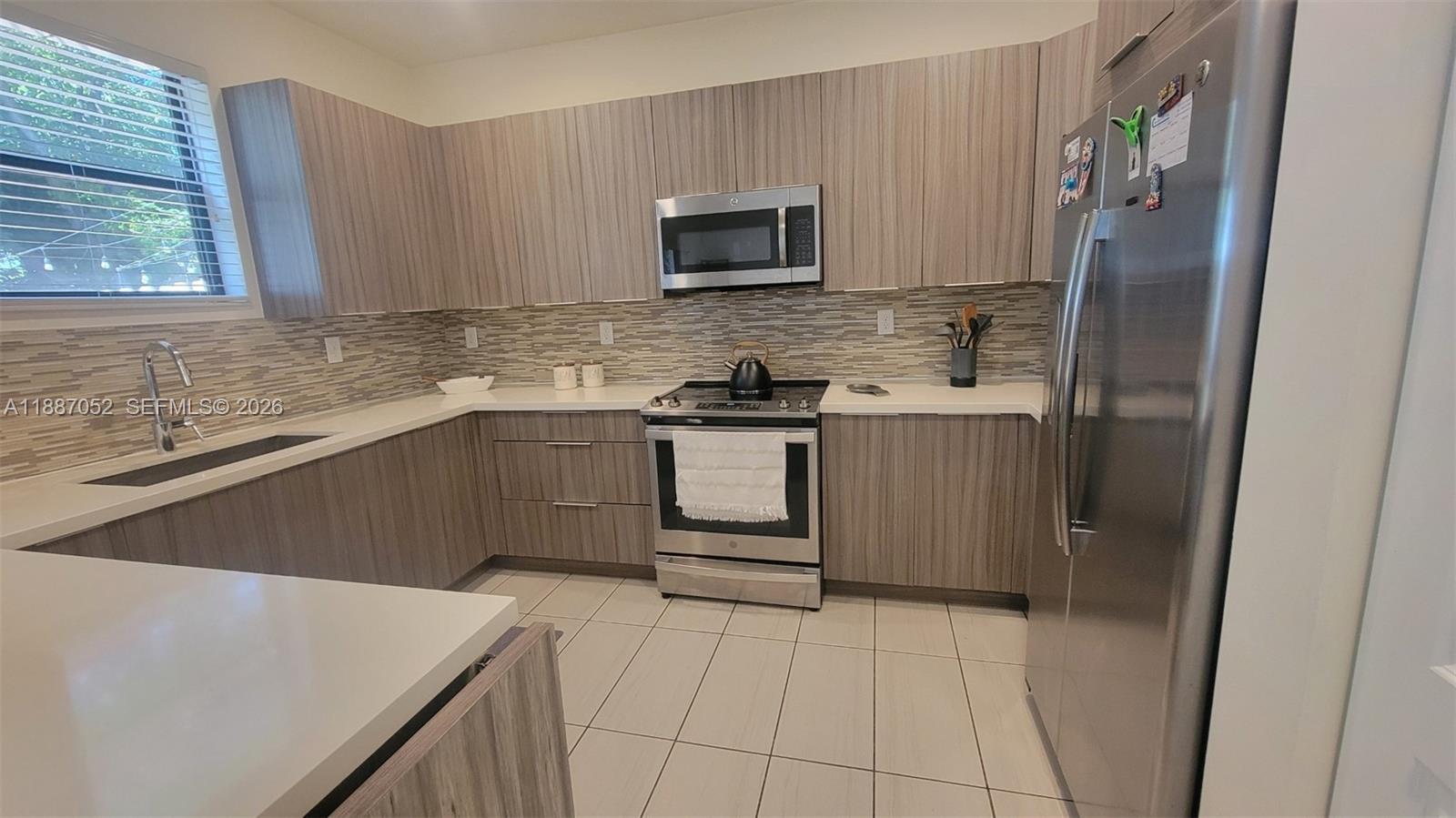8860 Northwest 103rd Path Doral, FL 33178 - Photo 14 of 52 a kitchen with stainless steel appliances a stove a sink and a microwave