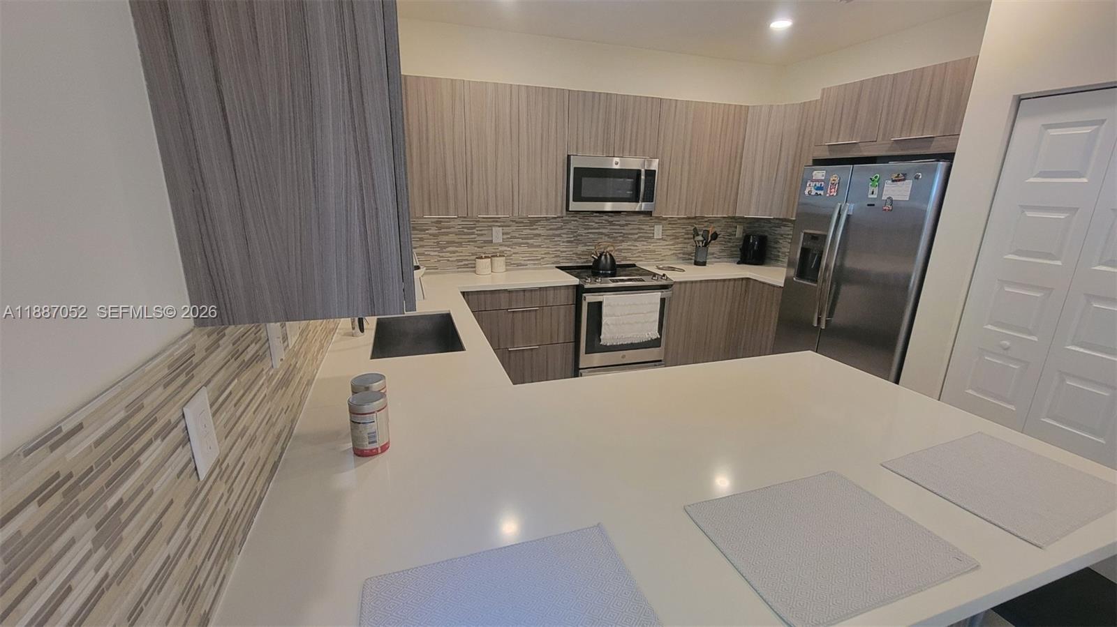 8860 Northwest 103rd Path Doral, FL 33178 - Photo 15 of 52 a kitchen with a refrigerator a stove top oven a sink and dishwasher