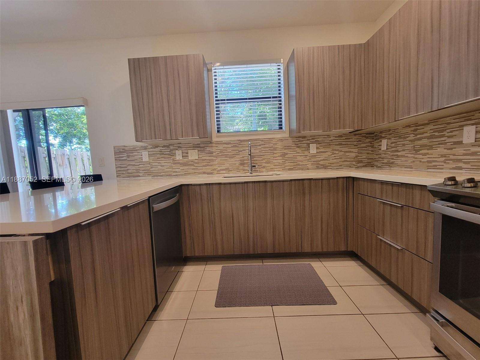 8860 Northwest 103rd Path Doral, FL 33178 - Photo 16 of 52 a kitchen with a sink window and cabinets