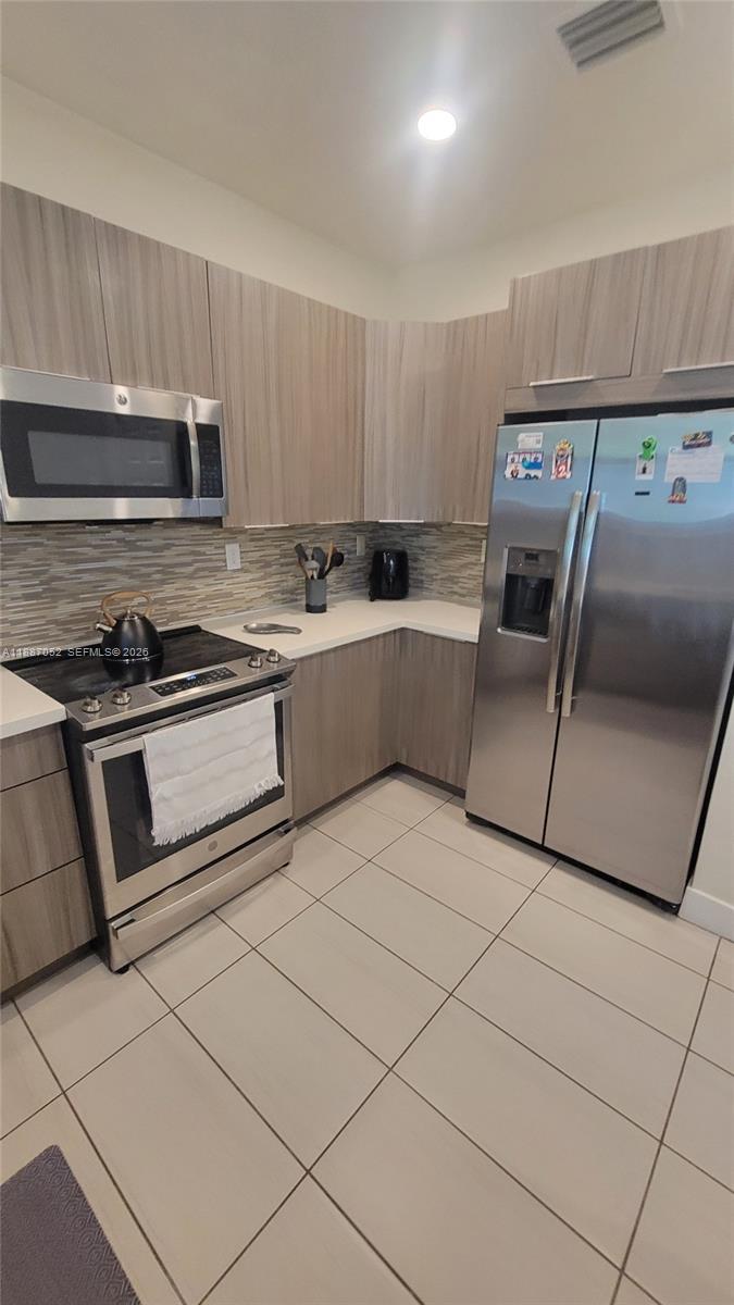 8860 Northwest 103rd Path Doral, FL 33178 - Photo 18 of 52 a kitchen with cabinets and steel stainless steel appliances