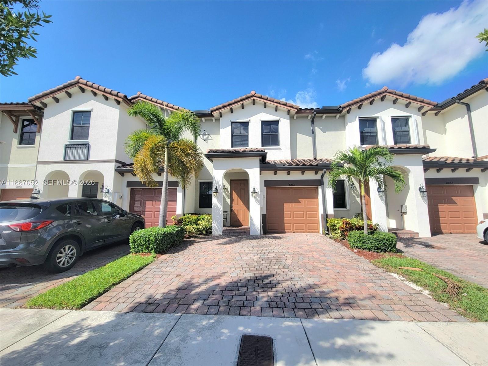 8860 Northwest 103rd Path Doral, FL 33178 - Photo 2 of 52 a front view of a house with a yard and garage