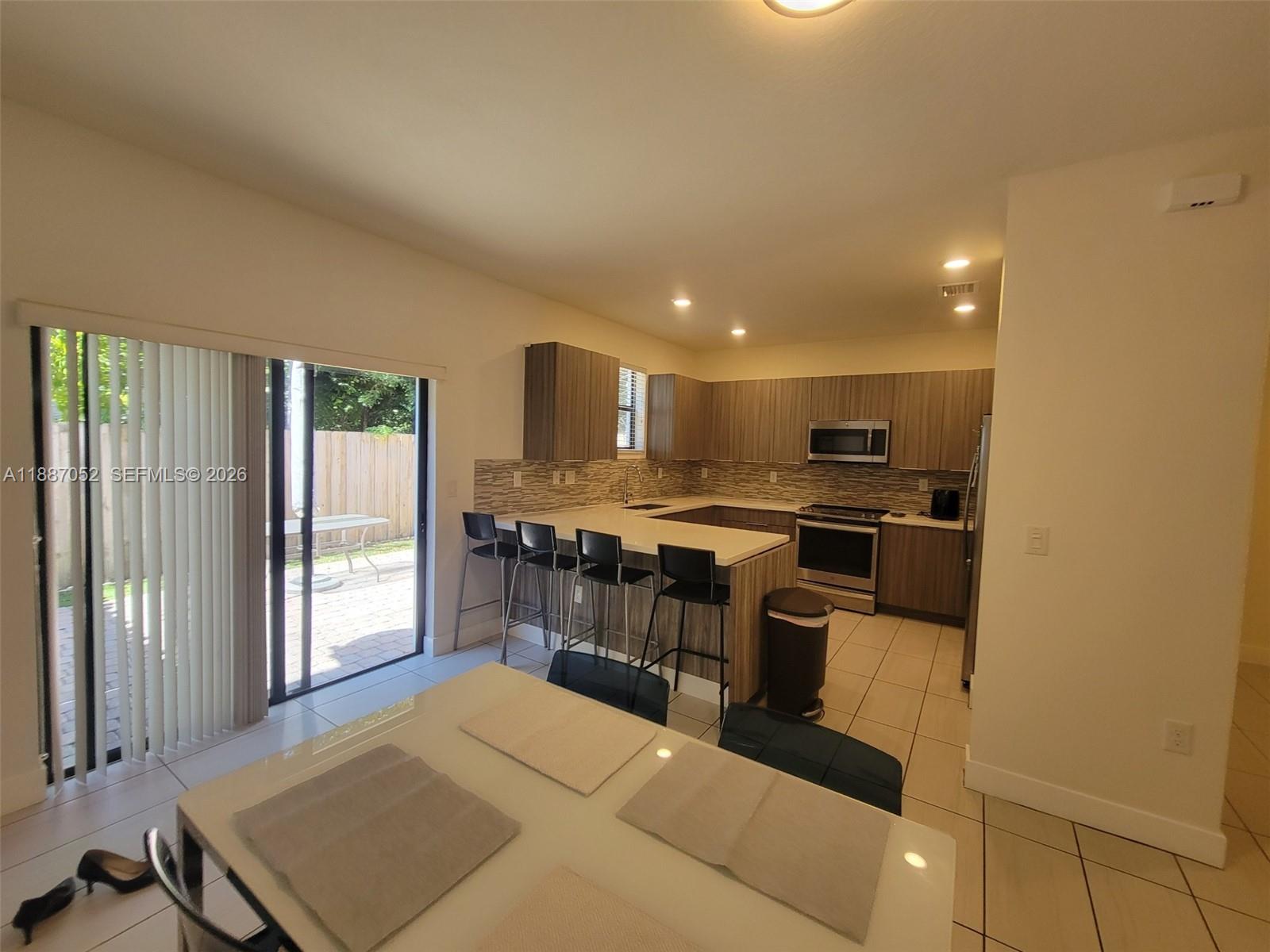 8860 Northwest 103rd Path Doral, FL 33178 - Photo 22 of 52 a kitchen with stainless steel appliances kitchen island granite countertop a refrigerator and cabinets