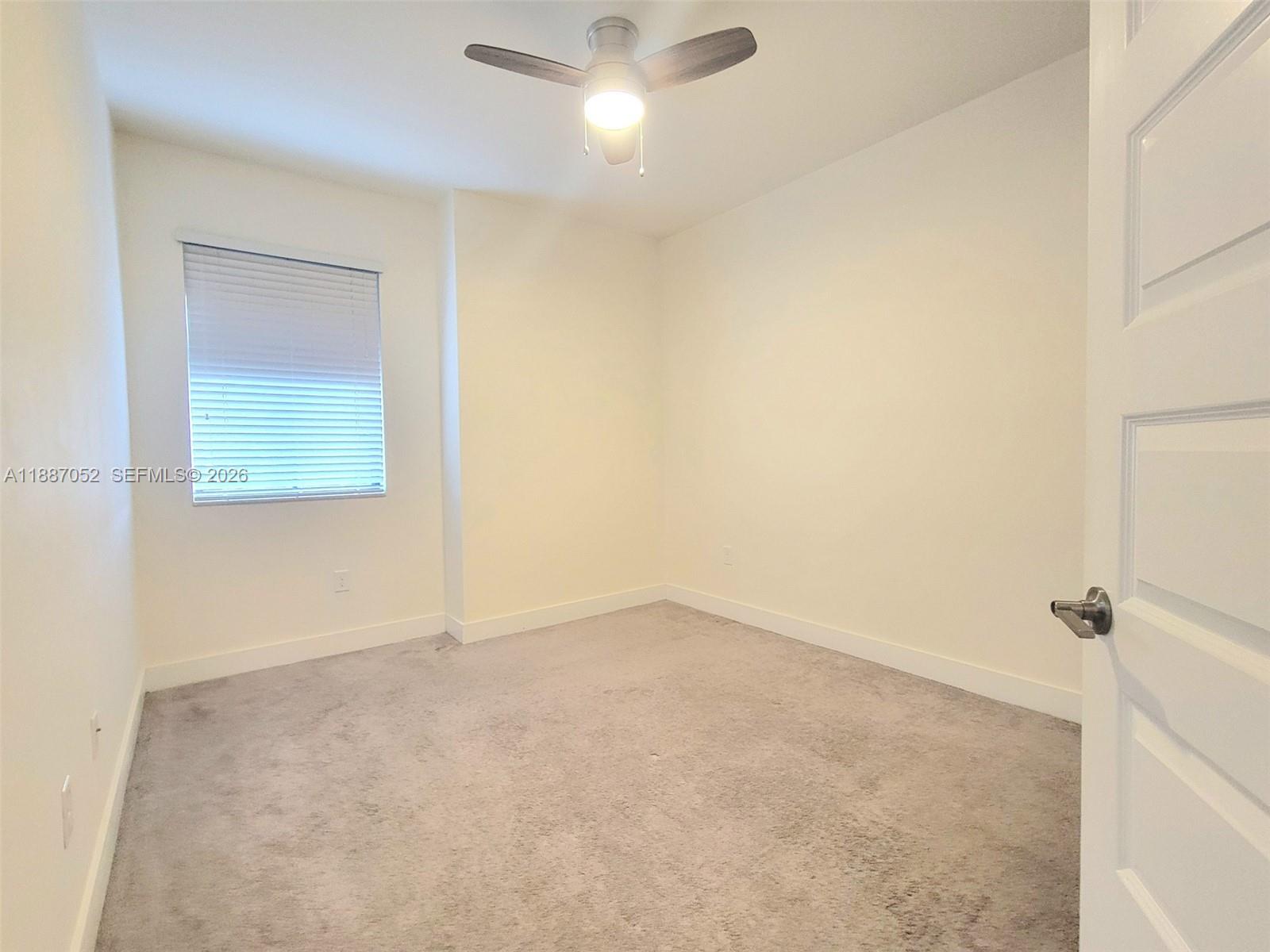 8860 Northwest 103rd Path Doral, FL 33178 - Photo 32 of 52 an empty room with a fan & a window