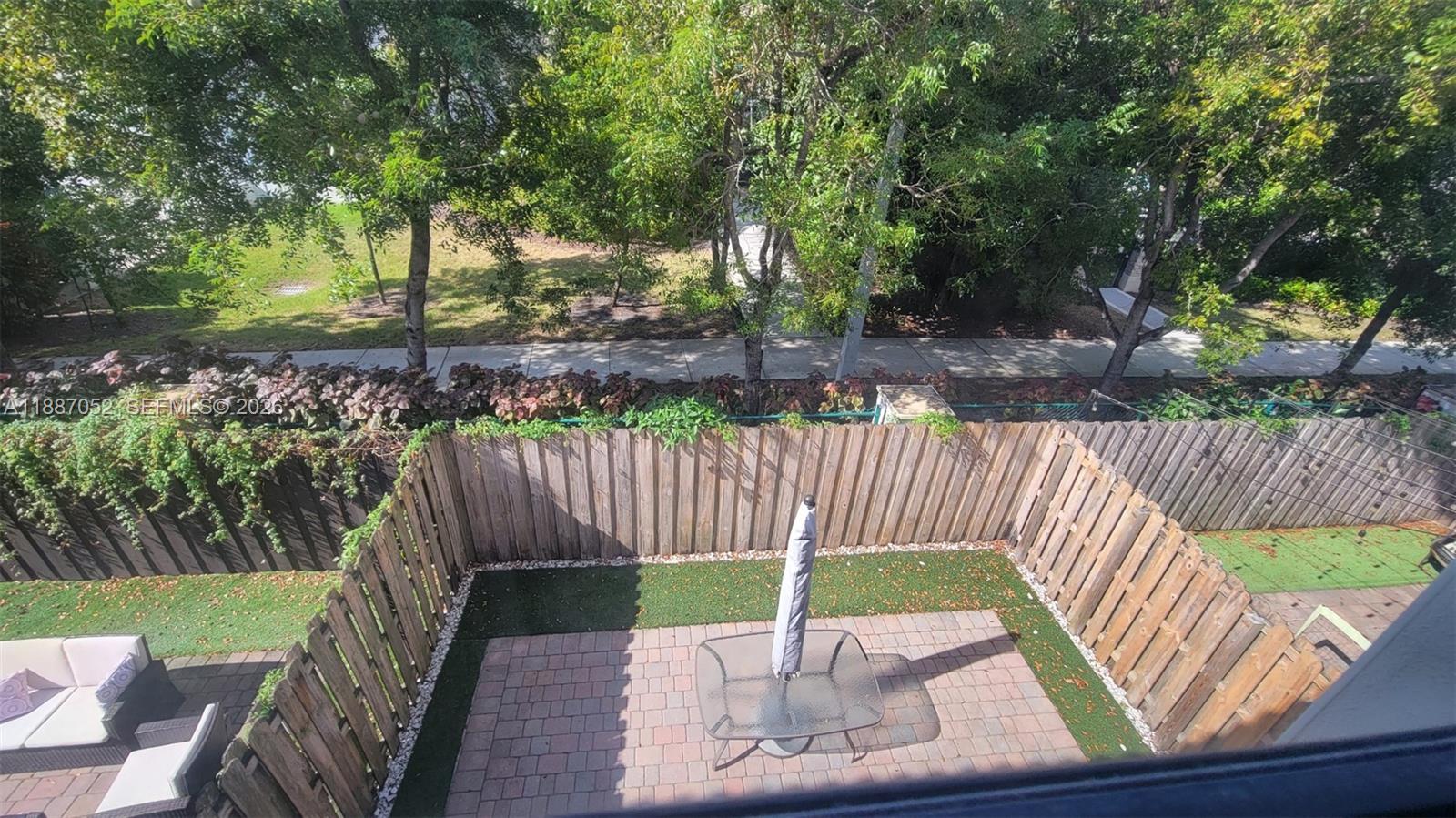 8860 Northwest 103rd Path Doral, FL 33178 - Photo 35 of 52 a wooden bench sitting in a yard with wooden fence