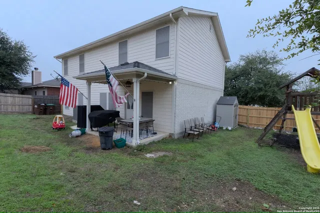 a view of a house with a backyard and a tree