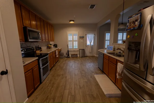 a kitchen with granite countertop wooden floors a stove and a sink