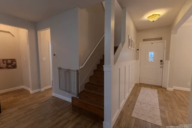 a view of hallway with stairs and wooden floor
