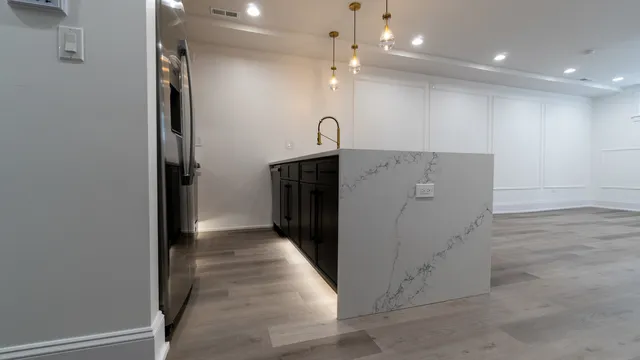 a kitchen with granite countertop a refrigerator and a sink