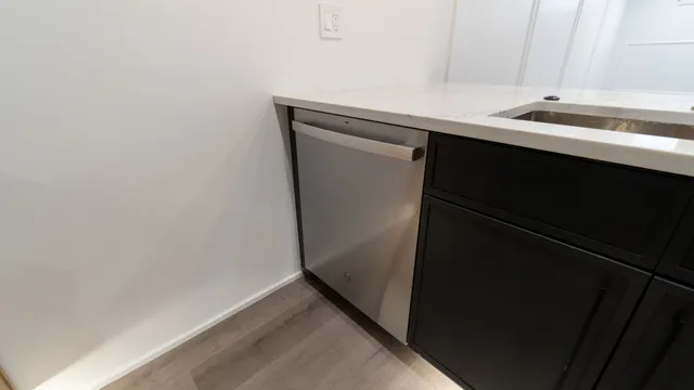 a view of a kitchen with a sink wooden floor and a window