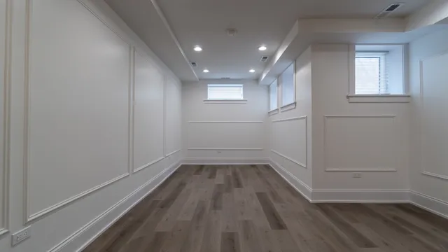 a view of empty room with wooden floor