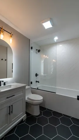a bathroom with a toilet sink vanity and mirror