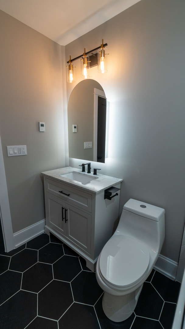 4745 North Beacon Street, Unit GS Chicago, IL 60640 - Photo 36 of 43 a bathroom with a toilet a sink and mirror