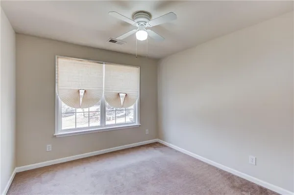 an empty room with windows and a ceiling fan