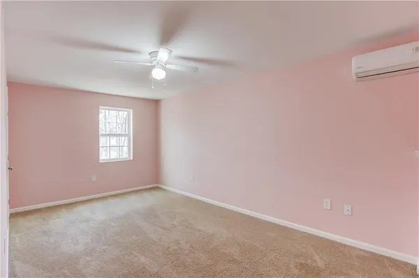 an empty room with a window and ceiling fan