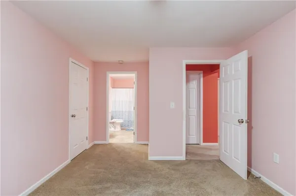 an empty room with closet and a bathroom