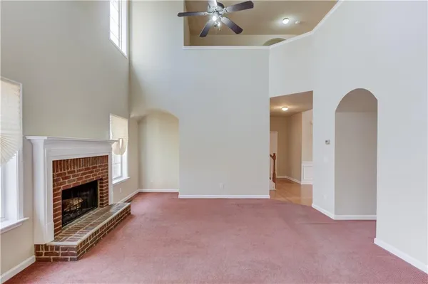 an empty room with fireplace and fan