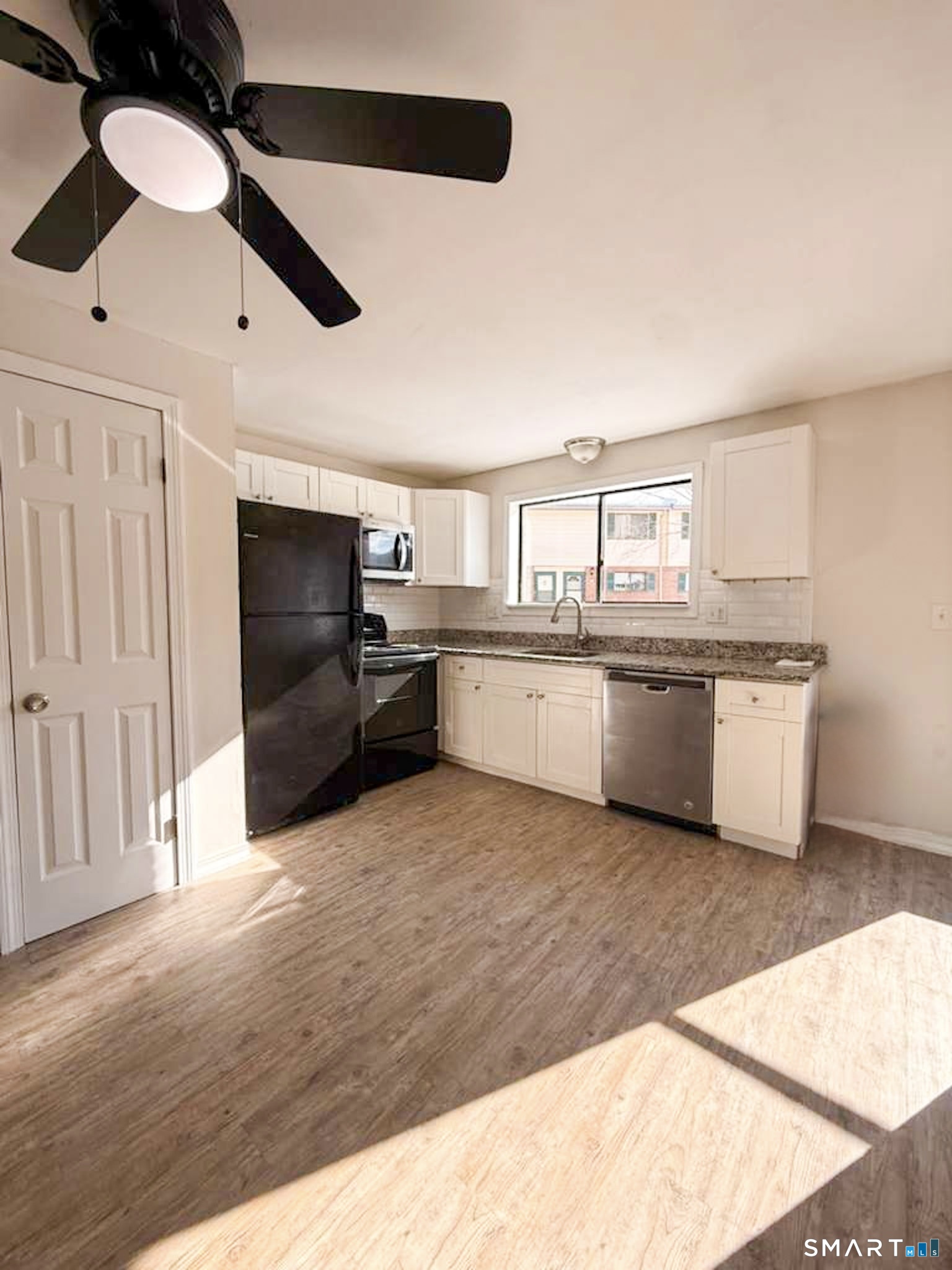 a large kitchen with stainless steel appliances kitchen island granite countertop a sink and cabinets