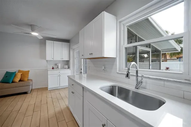 a kitchen that has a sink and a stove with wooden floors