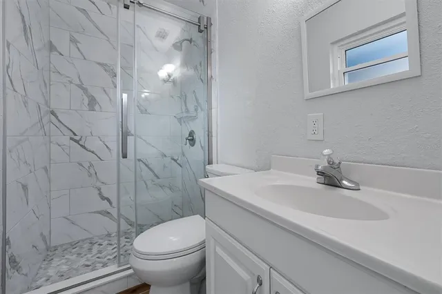 a bathroom with a sink a toilet and shower