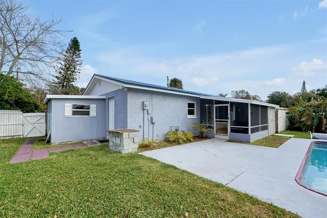 a front view of house with yard and trees in the background
