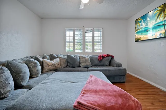 a living room with furniture and a wooden floor